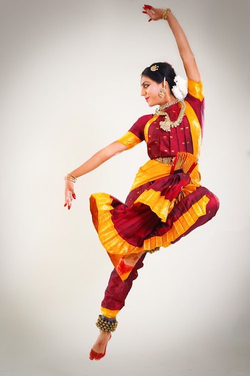 In a bright marigold and red costume, Srinidhi flies into the air